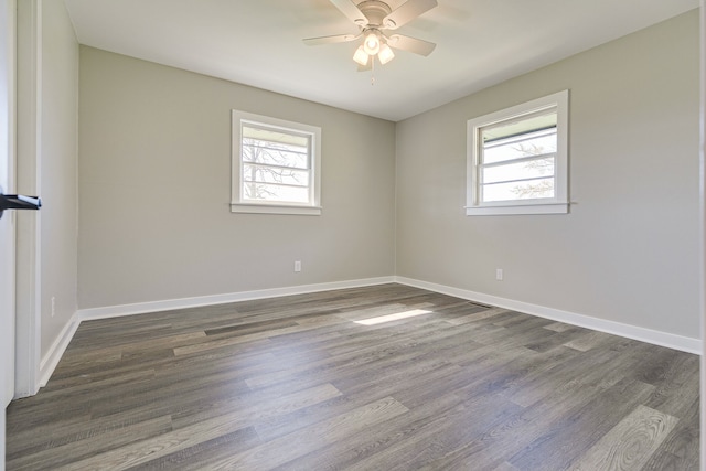 unfurnished room featuring a healthy amount of sunlight, dark wood-type flooring, and ceiling fan