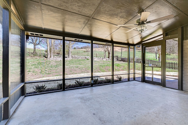 unfurnished sunroom with ceiling fan, vaulted ceiling, and a wealth of natural light