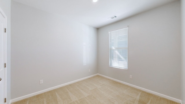 unfurnished room featuring light carpet