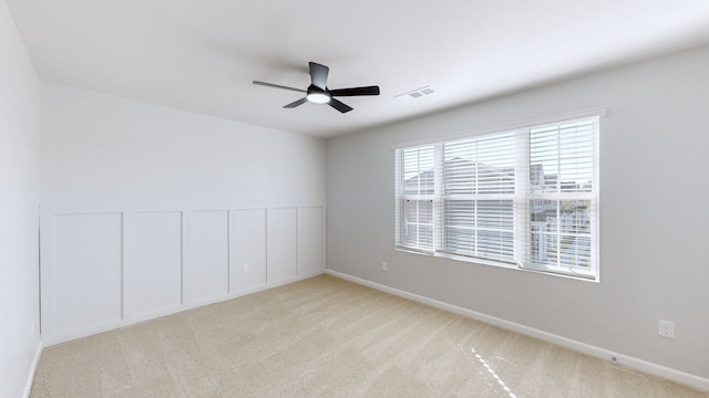 carpeted spare room with ceiling fan