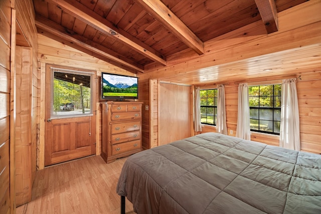 bedroom with wood ceiling, wood walls, and light hardwood / wood-style floors