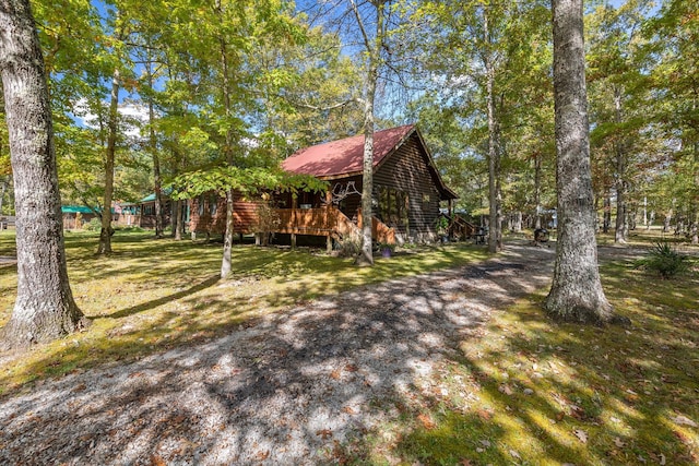 exterior space with a wooden deck and a lawn