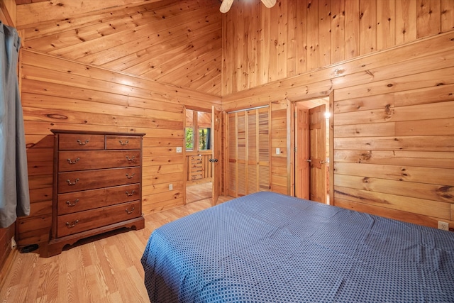 bedroom featuring a closet, light wood-type flooring, and wooden walls