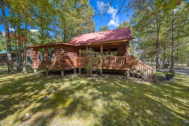 back of property featuring a wooden deck and a yard