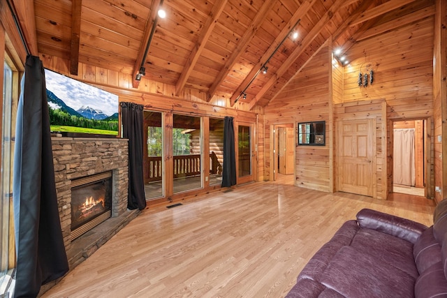 unfurnished living room featuring a stone fireplace, wood ceiling, beam ceiling, light wood-type flooring, and wood walls