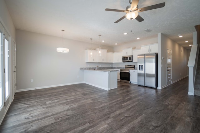 kitchen featuring white cabinets, kitchen peninsula, stainless steel appliances, and dark hardwood / wood-style floors