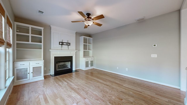 unfurnished living room with light hardwood / wood-style flooring, a fireplace, and ceiling fan