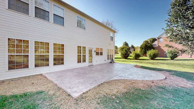 back of property with a patio area and a yard