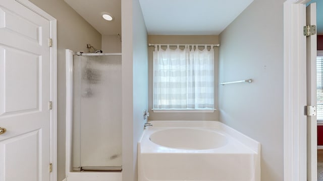 bathroom featuring a wealth of natural light and plus walk in shower