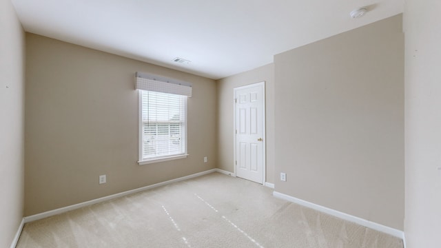 spare room featuring light colored carpet