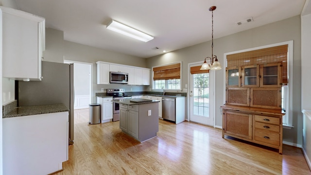 kitchen featuring a kitchen island, white cabinetry, light hardwood / wood-style flooring, and stainless steel appliances