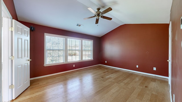 empty room with lofted ceiling, light wood-type flooring, and ceiling fan