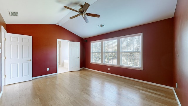 unfurnished bedroom featuring vaulted ceiling, ensuite bath, light wood-type flooring, and ceiling fan