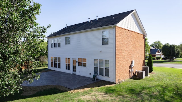 rear view of house featuring a yard, a patio area, and central AC