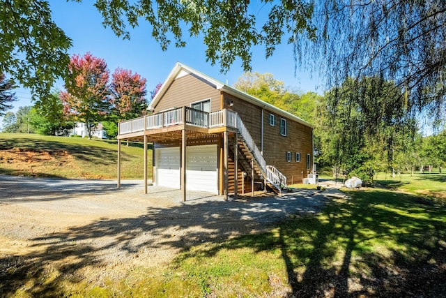 back of property featuring a yard, a deck, and a garage