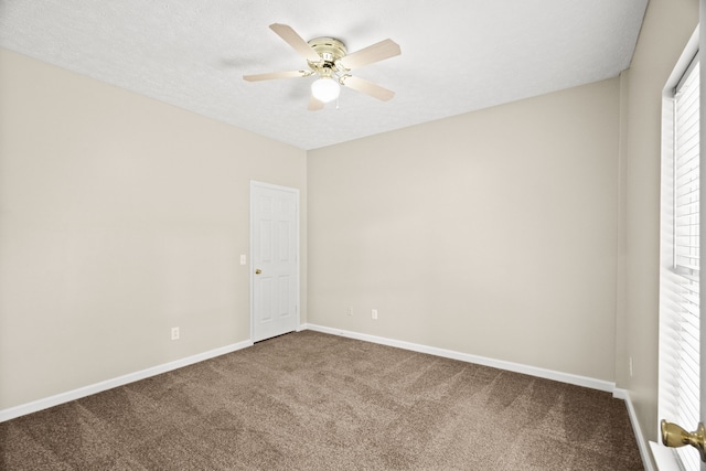 carpeted empty room with ceiling fan and a textured ceiling