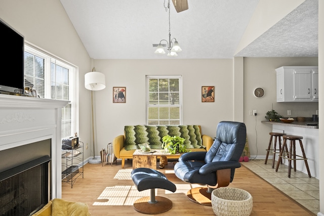 living area with light hardwood / wood-style flooring, plenty of natural light, and vaulted ceiling