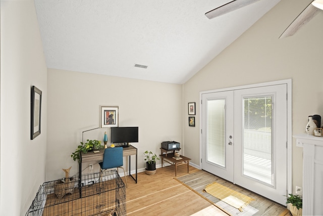 home office featuring french doors, a textured ceiling, wood-type flooring, and vaulted ceiling