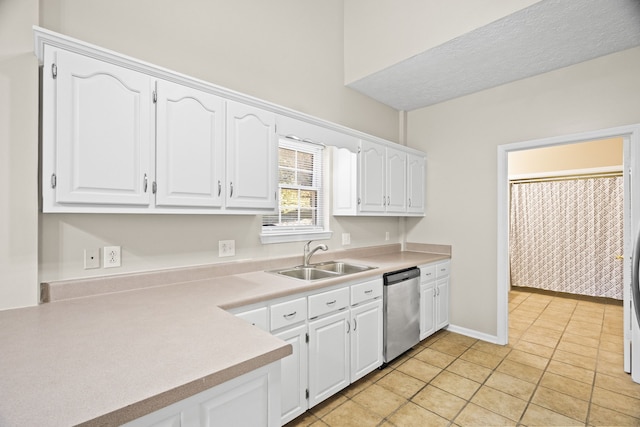 kitchen with white cabinetry, light tile patterned flooring, sink, and stainless steel dishwasher