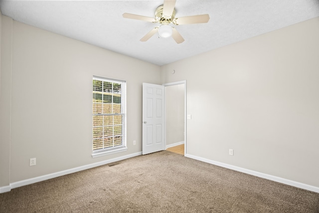 unfurnished room featuring ceiling fan and carpet floors