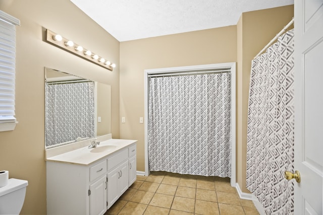 bathroom featuring a textured ceiling, walk in shower, toilet, vanity, and tile patterned floors