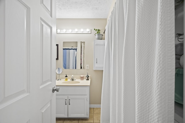 bathroom featuring vanity, a textured ceiling, and tile patterned floors