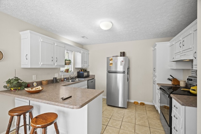 kitchen with a kitchen breakfast bar, kitchen peninsula, black appliances, light tile patterned flooring, and white cabinets