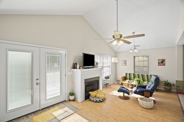 living room featuring ceiling fan, hardwood / wood-style flooring, high vaulted ceiling, and plenty of natural light