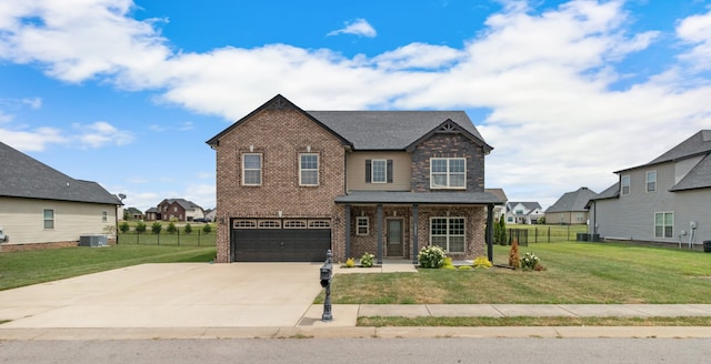 craftsman-style home with cooling unit, a front yard, and a garage