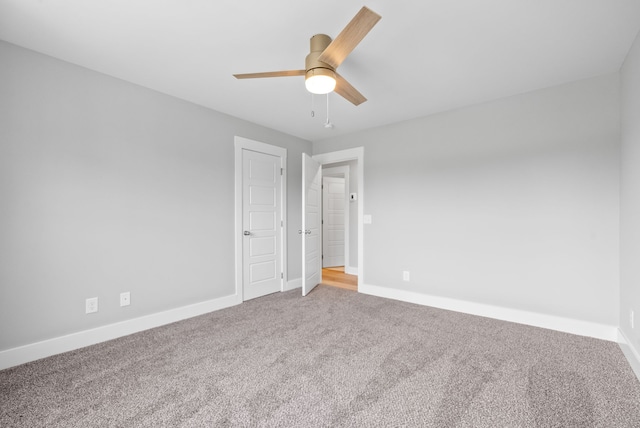 carpeted spare room with ceiling fan