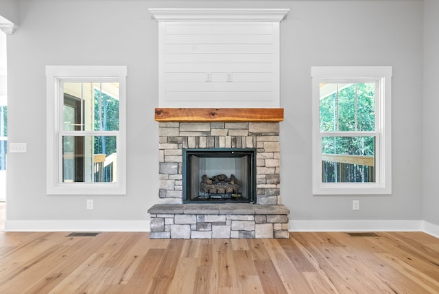 interior details featuring a stone fireplace and hardwood / wood-style floors