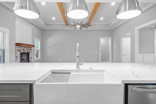 kitchen featuring light stone counters, a stone fireplace, dishwasher, and ceiling fan