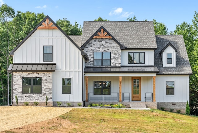 modern inspired farmhouse with a front lawn and covered porch