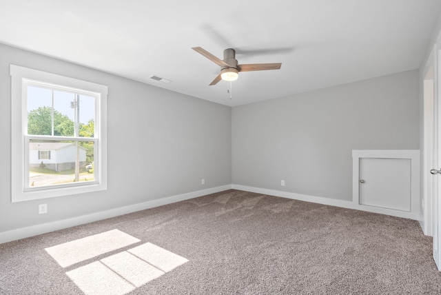 carpeted spare room featuring ceiling fan