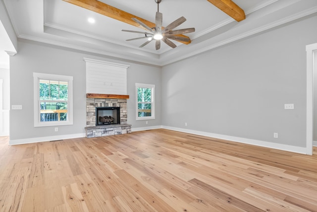 unfurnished living room with light hardwood / wood-style flooring, beam ceiling, a fireplace, and crown molding