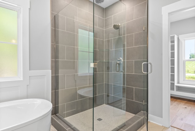 bathroom with hardwood / wood-style flooring and separate shower and tub