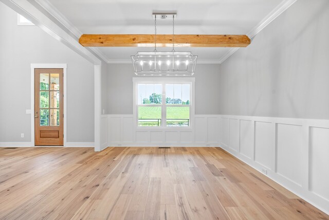 spare room featuring beam ceiling, ornamental molding, light hardwood / wood-style flooring, and plenty of natural light