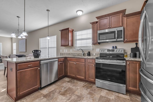 kitchen featuring appliances with stainless steel finishes, sink, kitchen peninsula, hanging light fixtures, and a notable chandelier