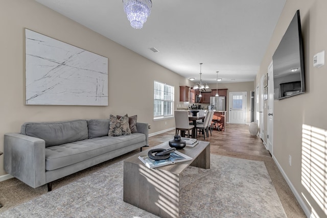 living room featuring wood-type flooring and an inviting chandelier