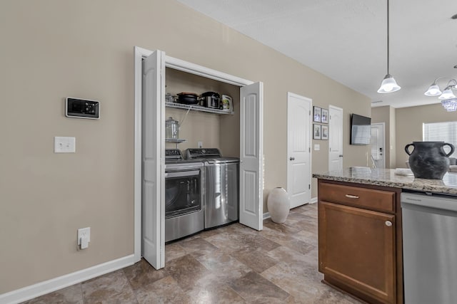 kitchen with washer and dryer, light stone countertops, dishwasher, and decorative light fixtures