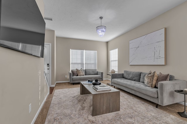 living room with a chandelier and light colored carpet