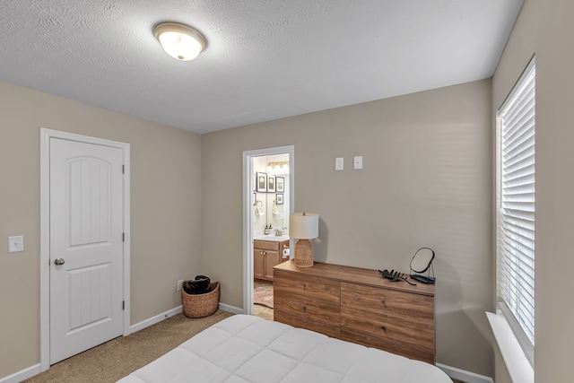 bedroom featuring connected bathroom, a textured ceiling, multiple windows, and carpet floors