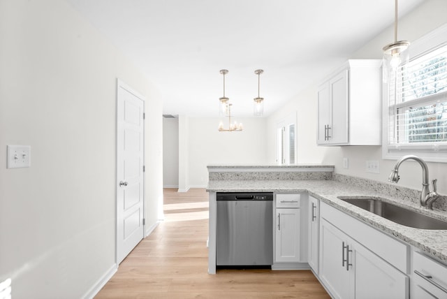 kitchen with stainless steel dishwasher, sink, decorative light fixtures, light hardwood / wood-style floors, and white cabinetry