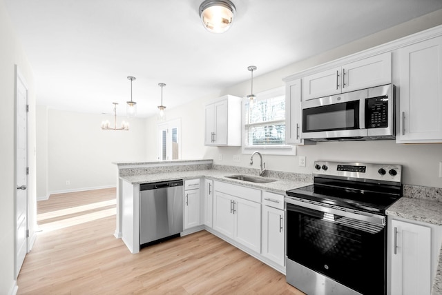 kitchen with sink, decorative light fixtures, light hardwood / wood-style floors, white cabinetry, and stainless steel appliances