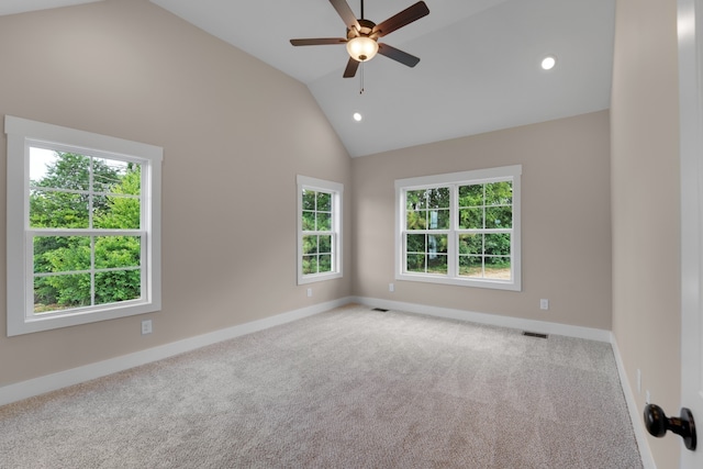 carpeted empty room featuring ceiling fan, high vaulted ceiling, and a wealth of natural light