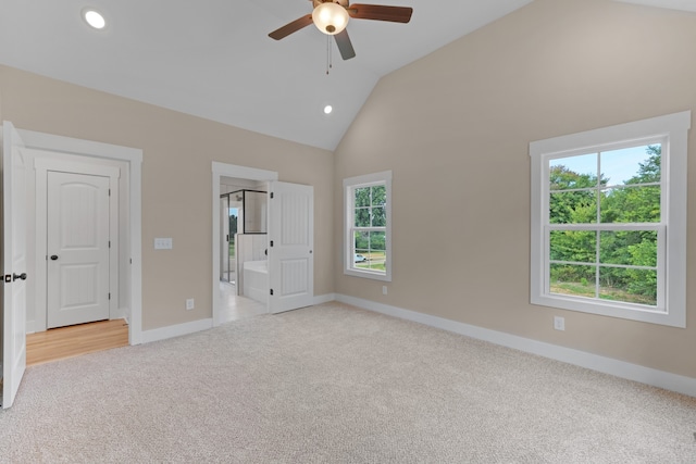 unfurnished bedroom featuring ceiling fan, high vaulted ceiling, multiple windows, and light colored carpet