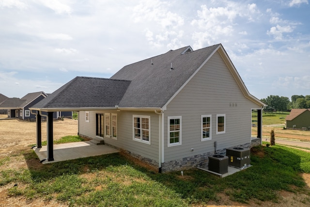 rear view of property featuring a patio area, a lawn, and central AC unit