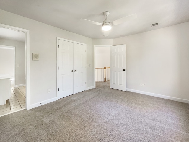 unfurnished bedroom featuring a closet, ceiling fan, and light carpet