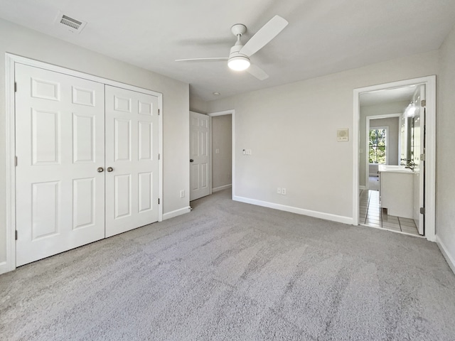 unfurnished bedroom with light carpet, a closet, and ceiling fan