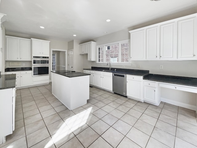 kitchen featuring white cabinetry, light tile patterned floors, stainless steel appliances, and a center island